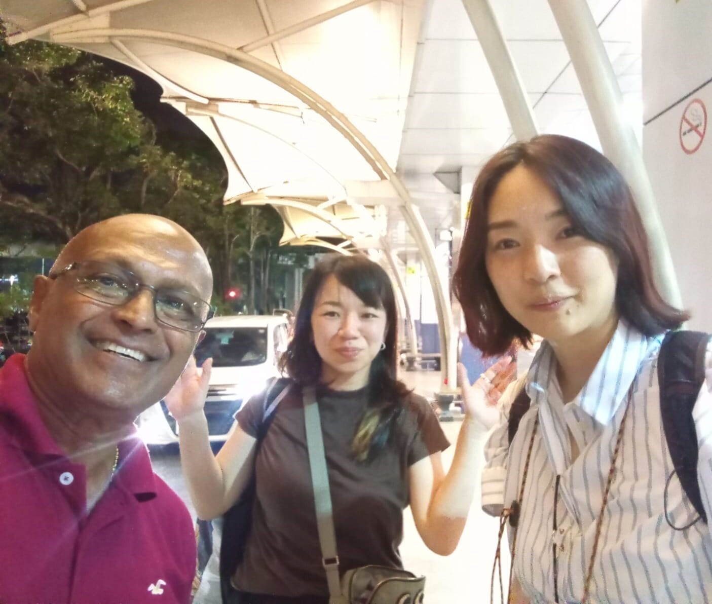 空港でドライバーと記念撮影する旅行者