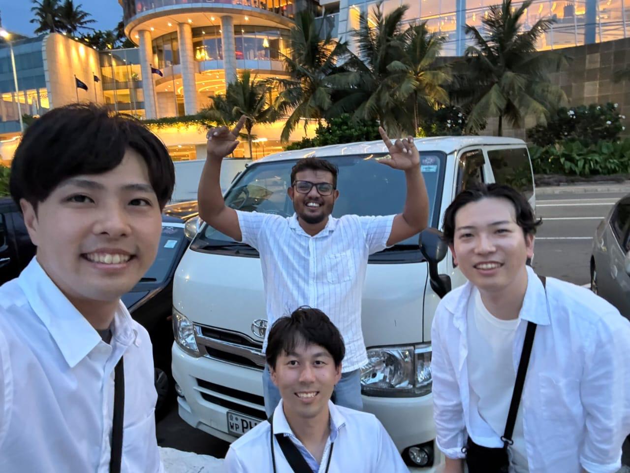 専用車の前で旅行者と記念撮影するランカミーのドライバー