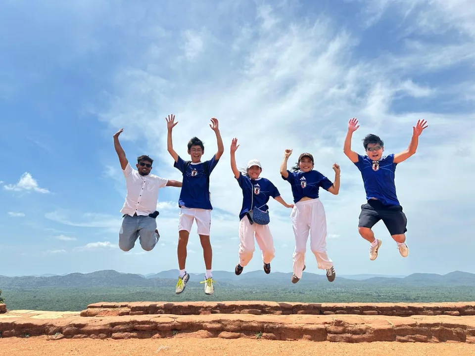 屋外でドライバーとジャンプして記念撮影するI様ご家族