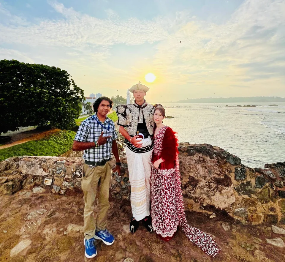 海辺の夕景でドライバーと記念撮影するM様ご夫妻